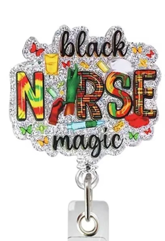 A rhinestone-embellished badge reel or card holder featuring the words 'black nurse magic' in stylized lettering with colorful medical-themed illustrations, shown on a white background.