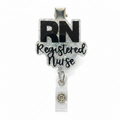 A retractable badge reel featuring a decorative charm with the text 'RN Registered Nurse' in black lettering over a silver glitter background, attached to a clear plastic clip with a silver metal snap.